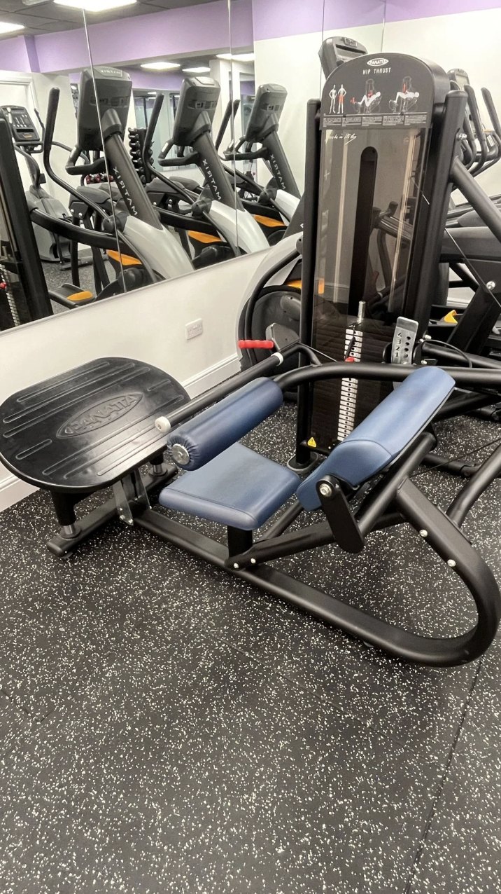 A hip thrust machine in front of cross trainers