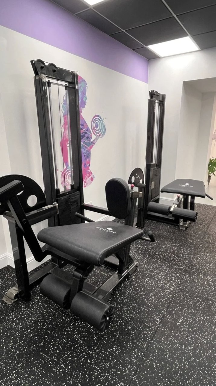 Leg extension and leg curl machines beside the painted mural